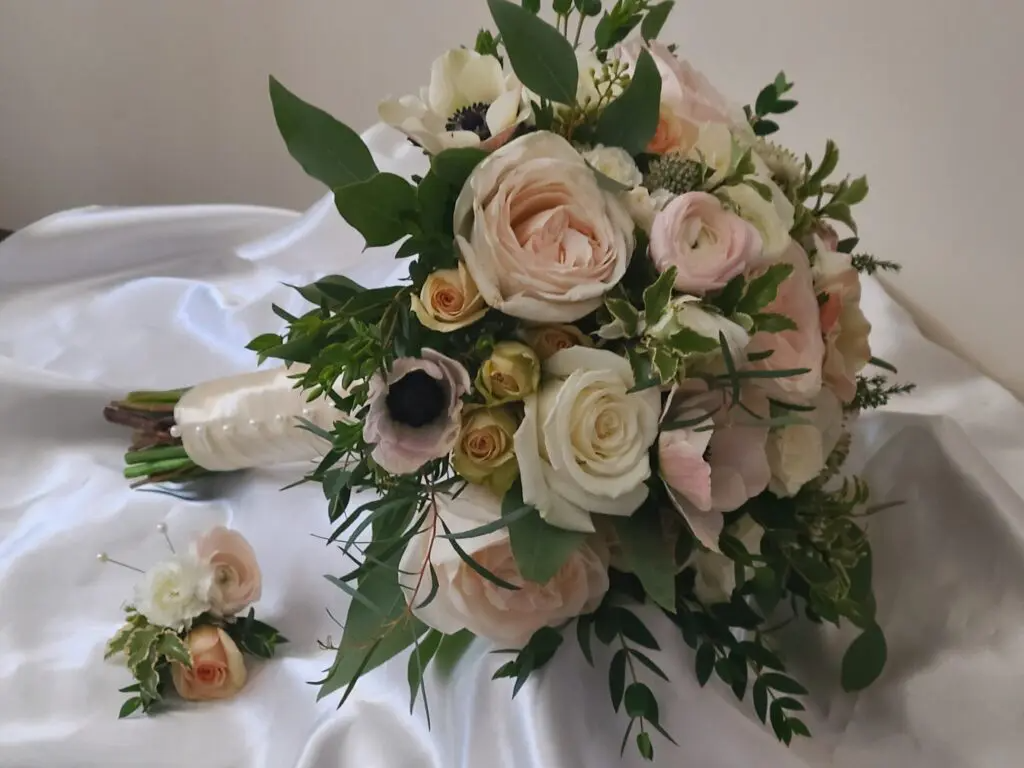 A bouquet of flowers is sitting on a white cloth on a table.