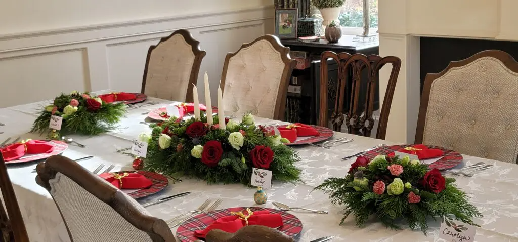 A dining room table with plates , candles , and flowers on it.