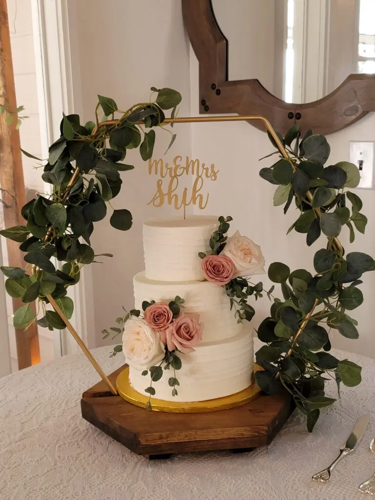 A wedding cake is sitting on top of a wooden table.