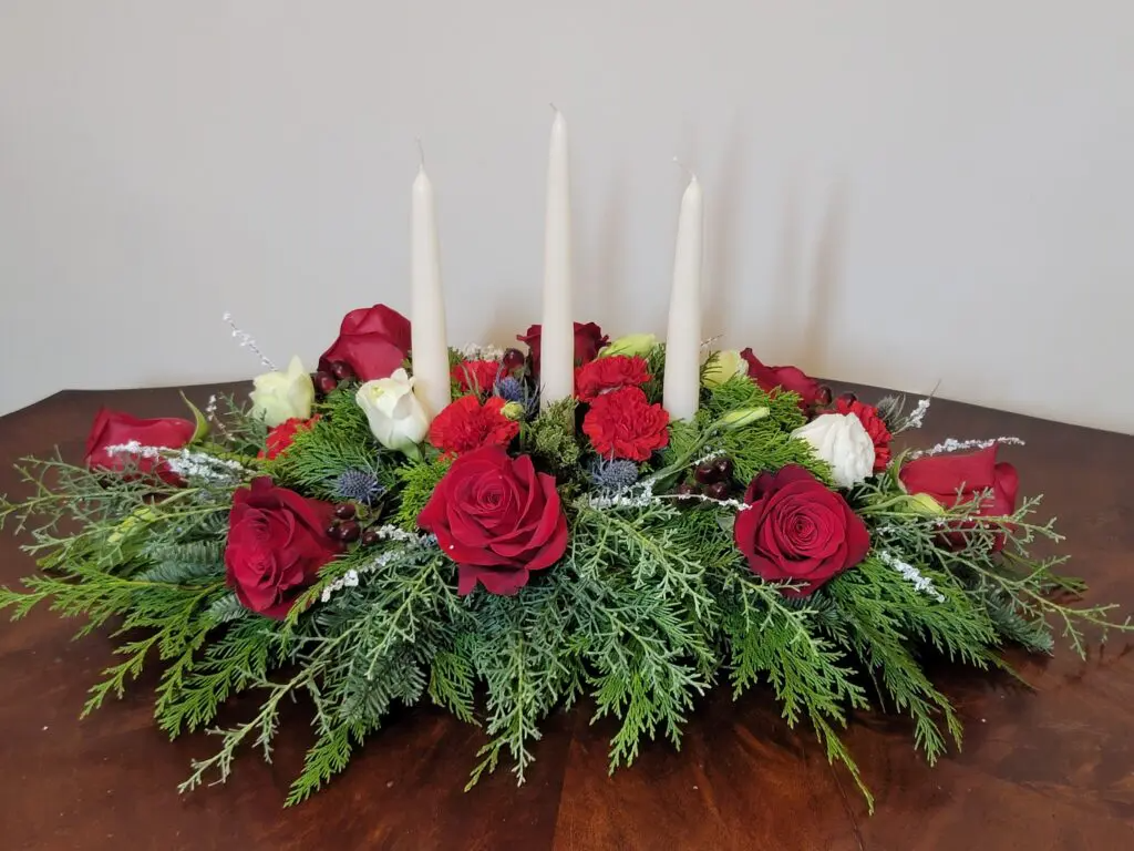 A table with flowers and candles on it.