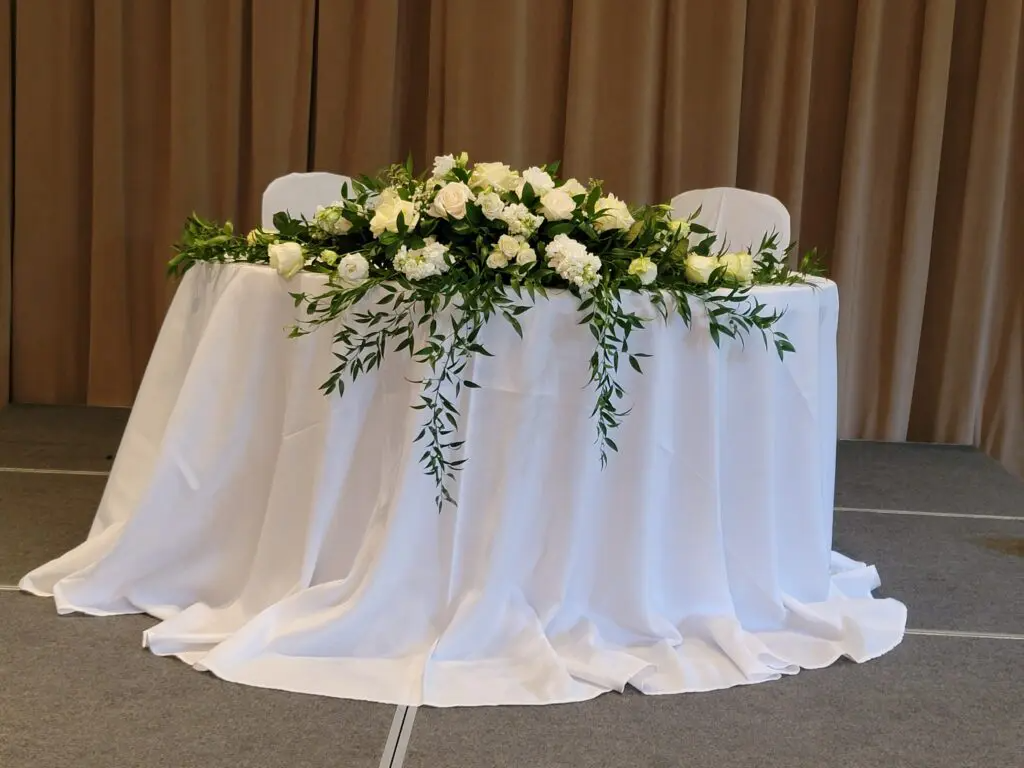 A table with a white tablecloth and flowers on it