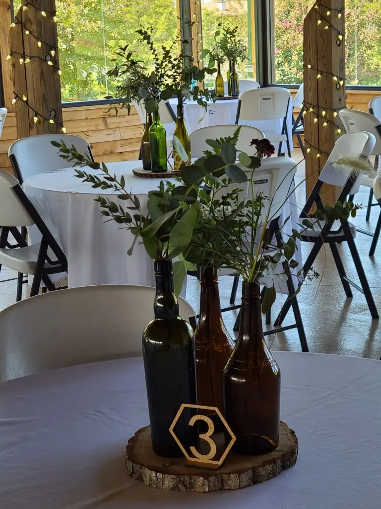 A table with bottles of wine and flowers on it.