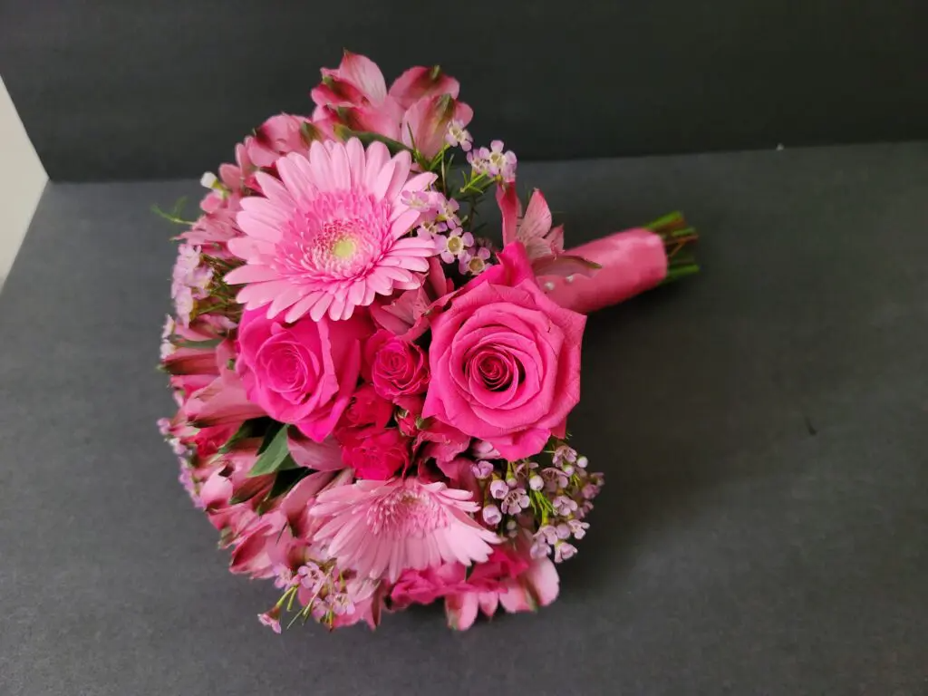 A bouquet of pink flowers is sitting on a table.