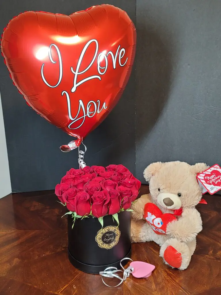 A teddy bear is sitting next to a heart shaped balloon that says `` i love you ''.