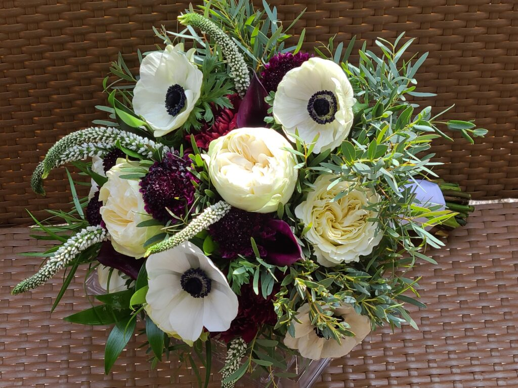 A bouquet of flowers is sitting on a wicker table.