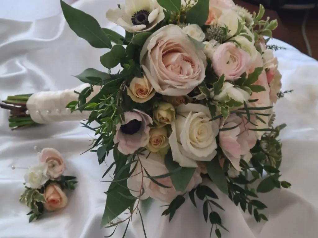 A bouquet of flowers and a boutonniere on a table