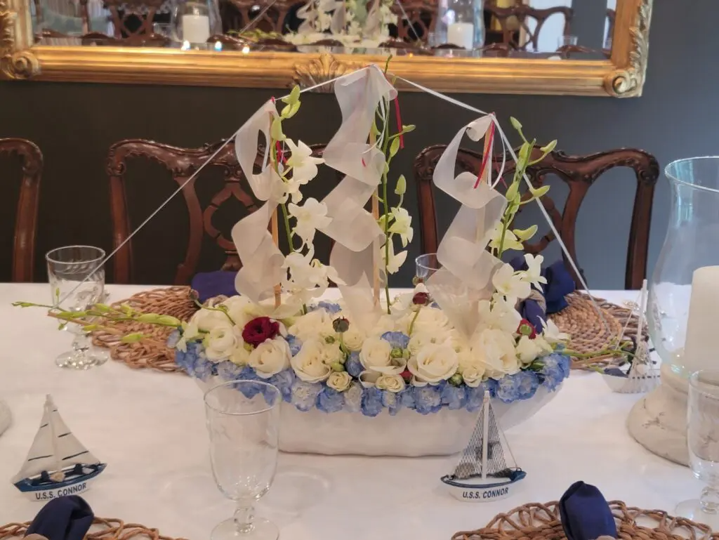 A table with flowers and a sailboat on it