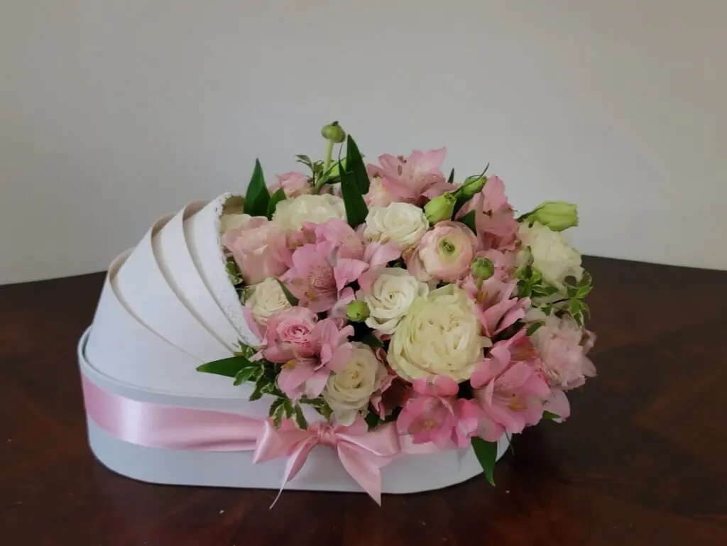 A white carriage filled with pink and white flowers