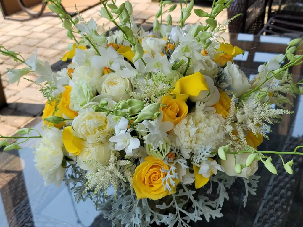 A bouquet of yellow and white flowers is sitting on a table.