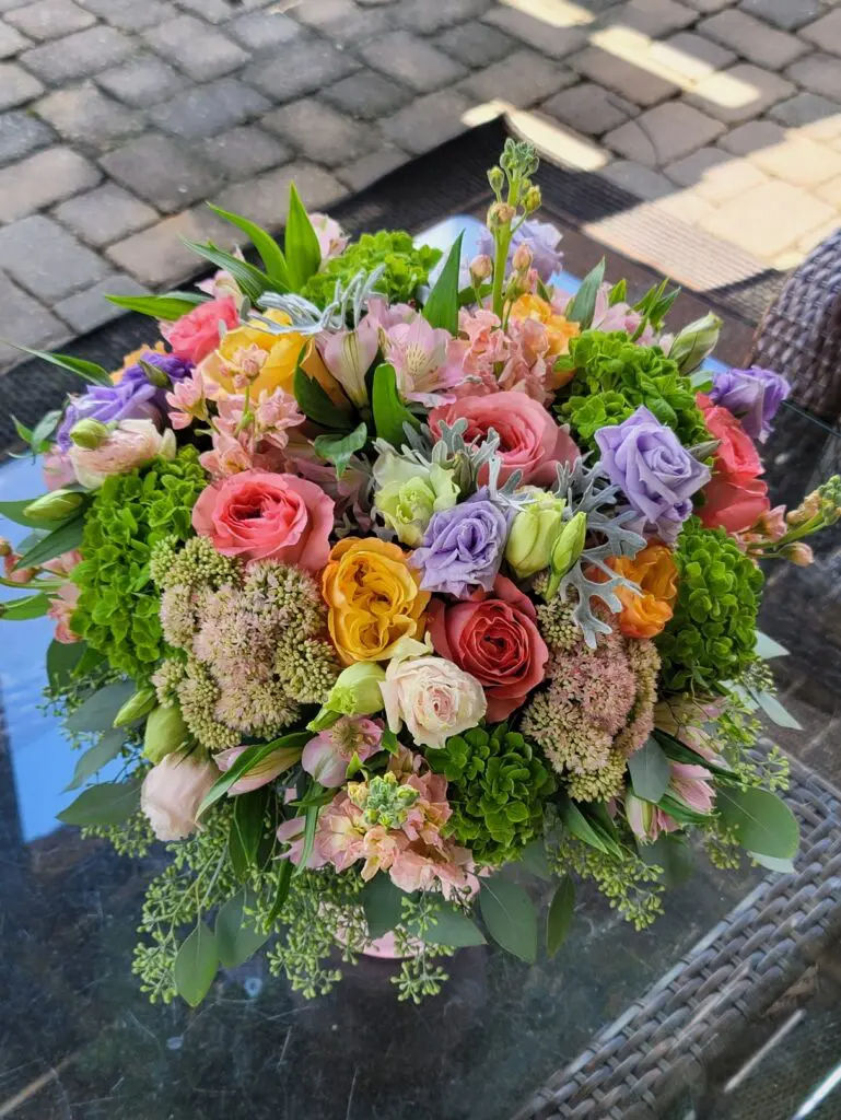 A bouquet of flowers is sitting on a glass table.