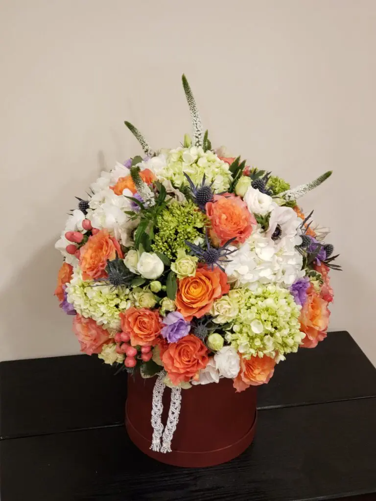 A box filled with flowers is sitting on a table.
