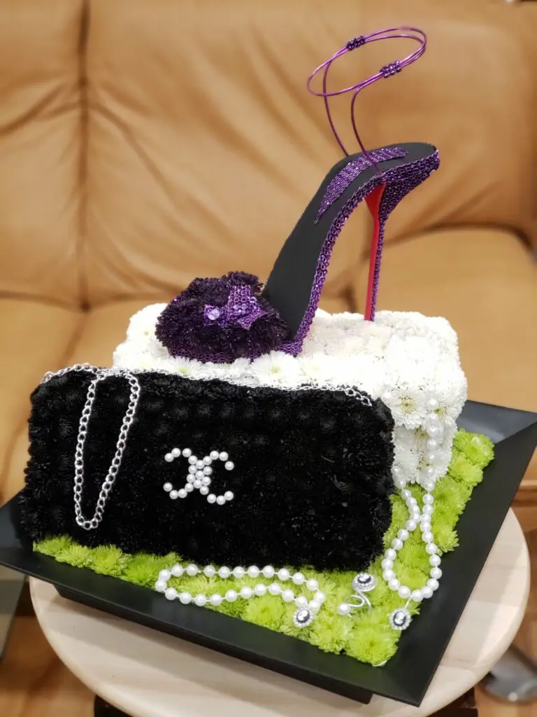 A black and white purse with a purple shoe on top