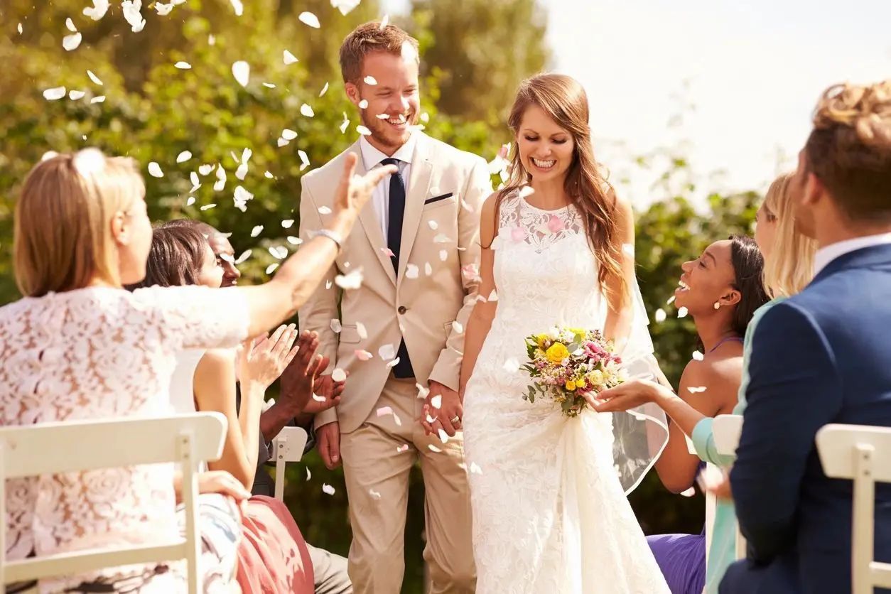 A bride and groom are walking down the aisle at their wedding.