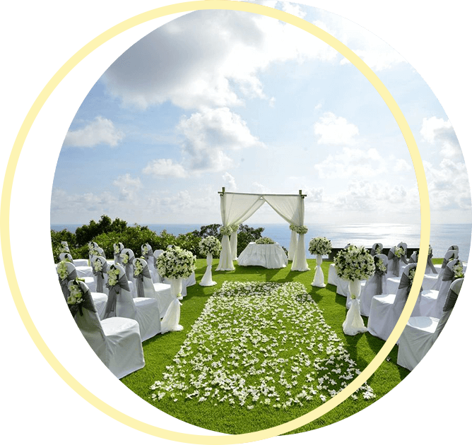 A wedding ceremony is set up on a hill overlooking the ocean