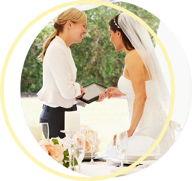 A woman is holding a tablet next to a bride