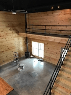 A room with wooden walls and a staircase leading to the second floor.