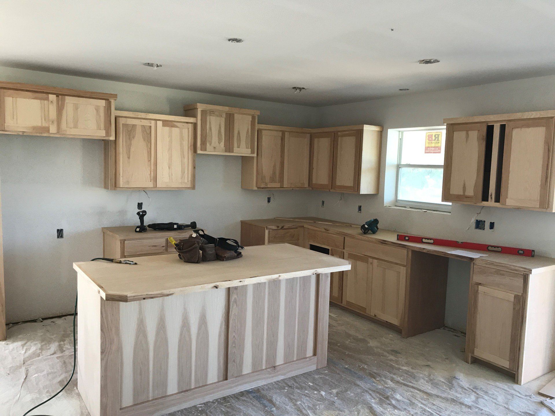 A kitchen under construction with wooden cabinets and a large island.