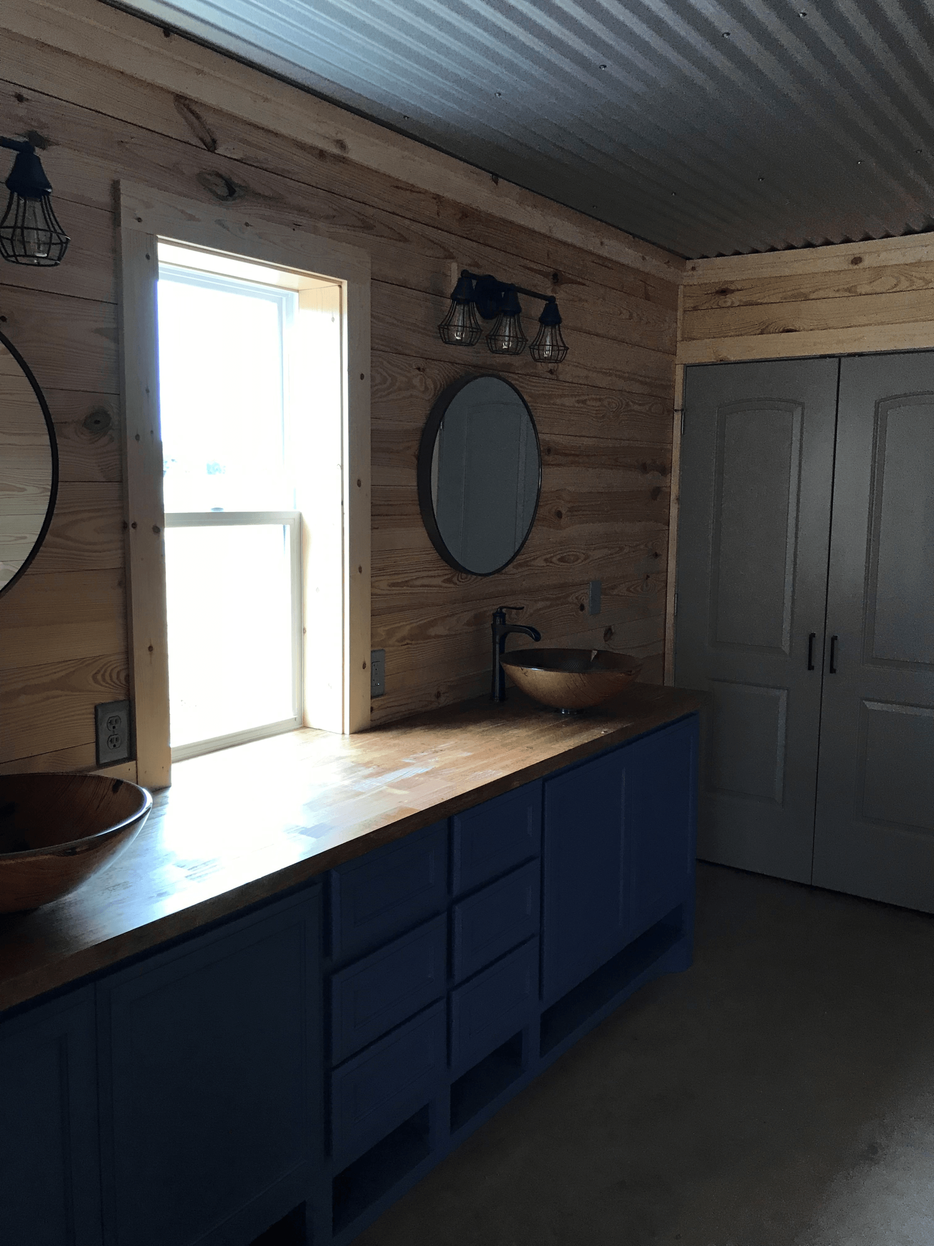 A bathroom with a sink , mirror and window