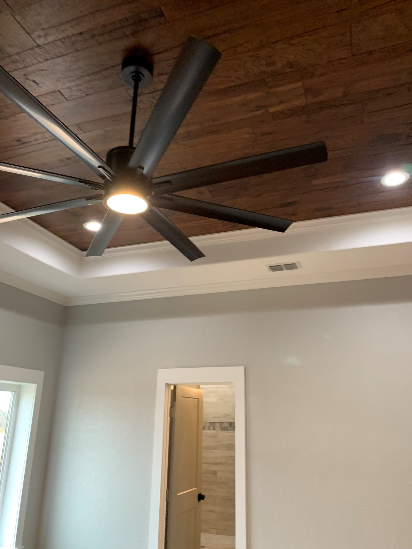 A ceiling fan is hanging from the ceiling of a room.