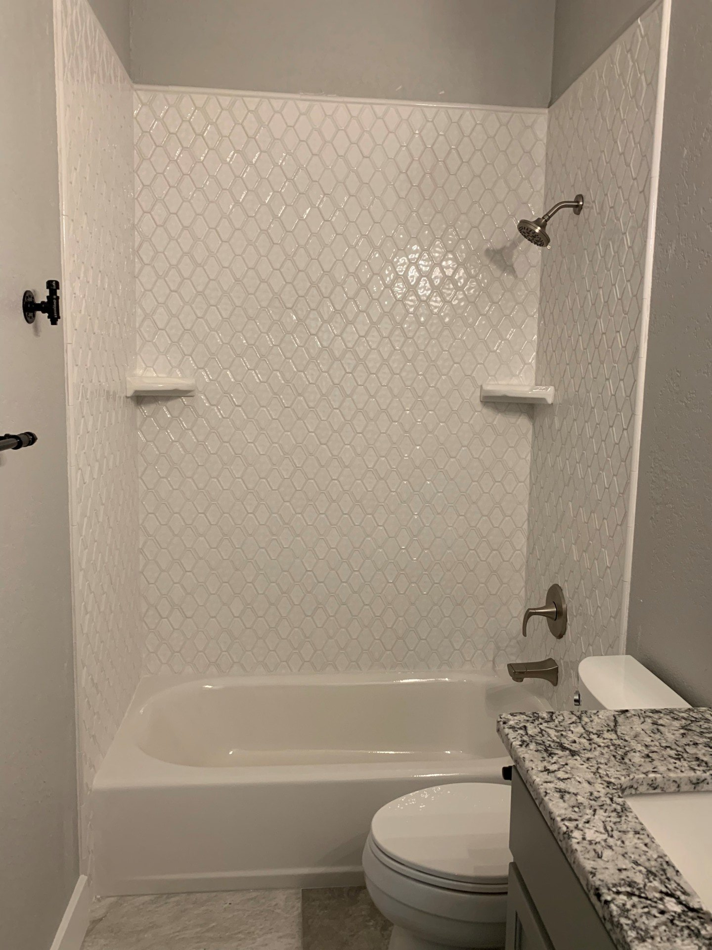 A bathroom with a bathtub , toilet , sink and shower.