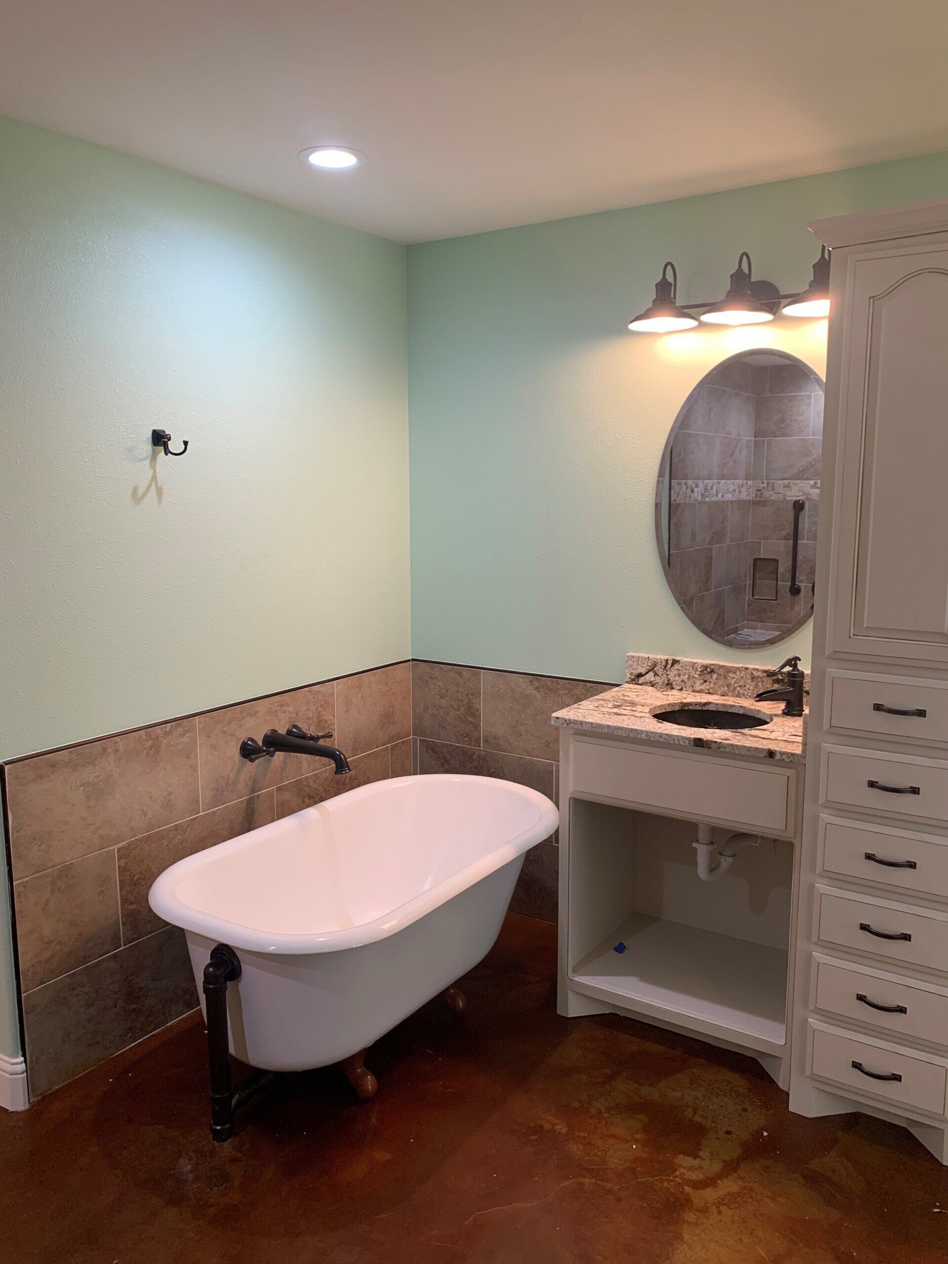 A bathroom with a bathtub , sink and mirror.