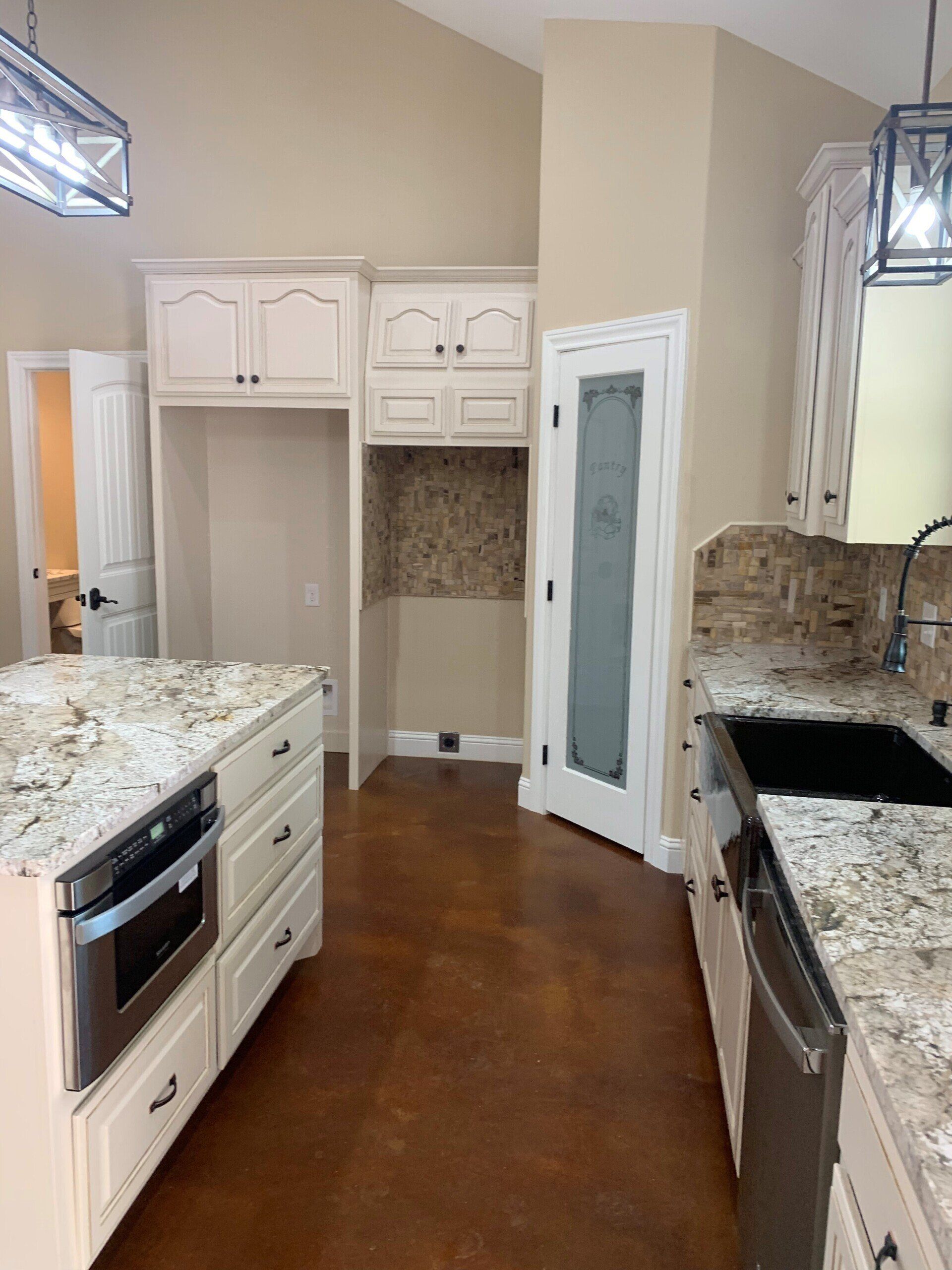 A kitchen with granite counter tops , stainless steel appliances , and white cabinets.