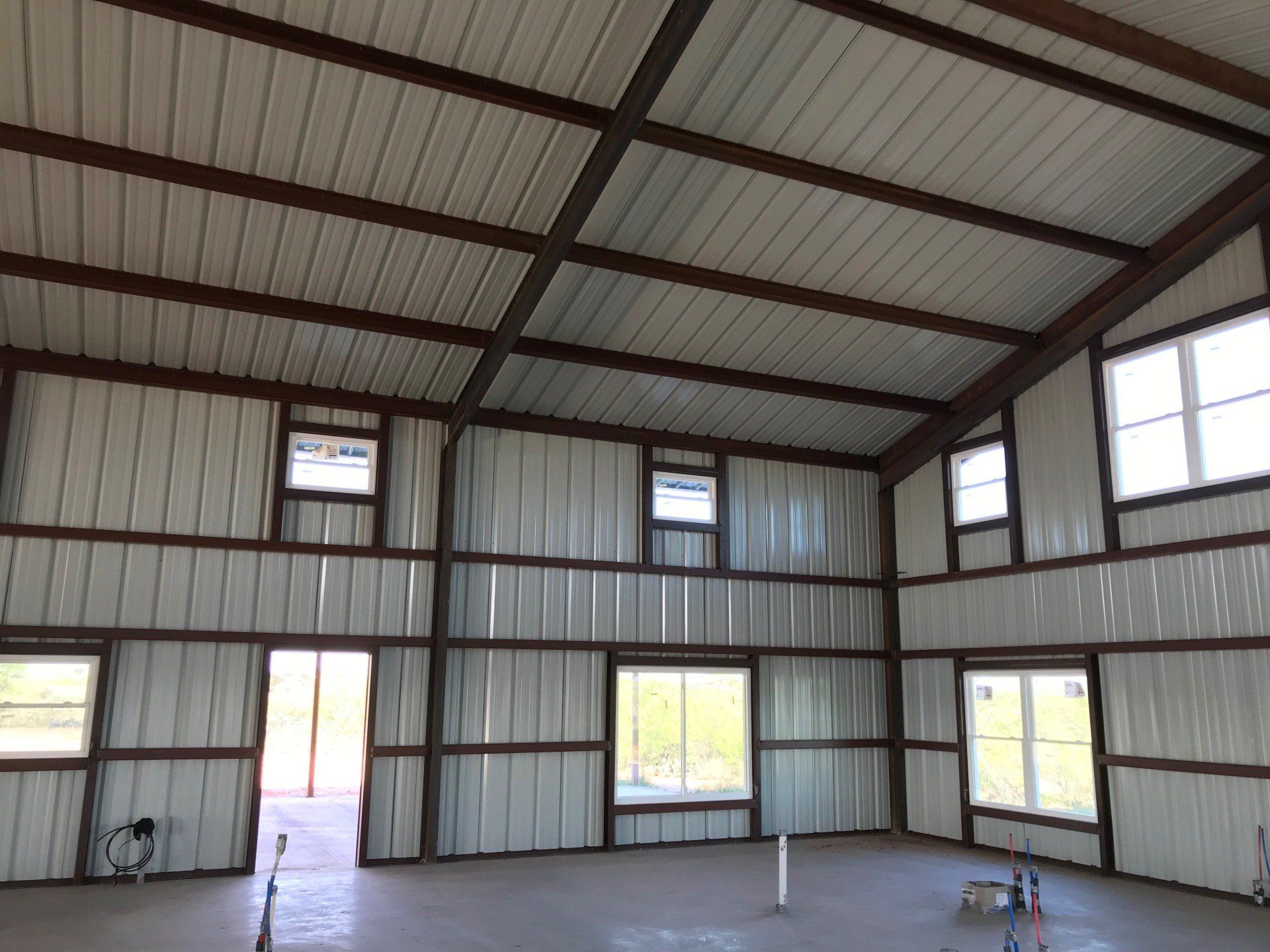 The inside of a metal building with a lot of windows