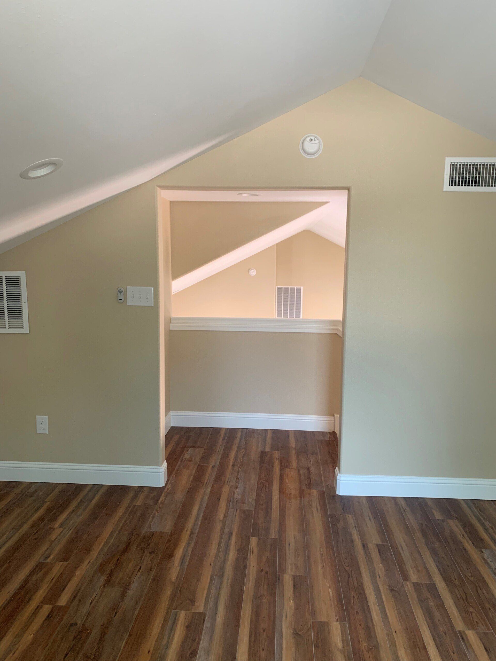 A living room with hardwood floors and a vaulted ceiling.