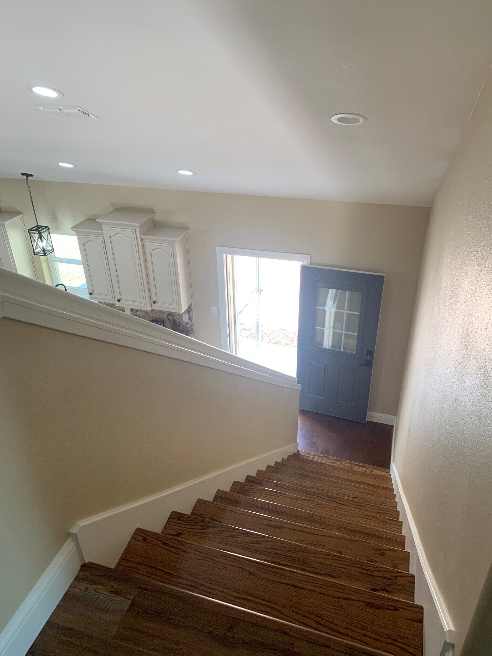 A set of wooden stairs leading up to a door in a house.
