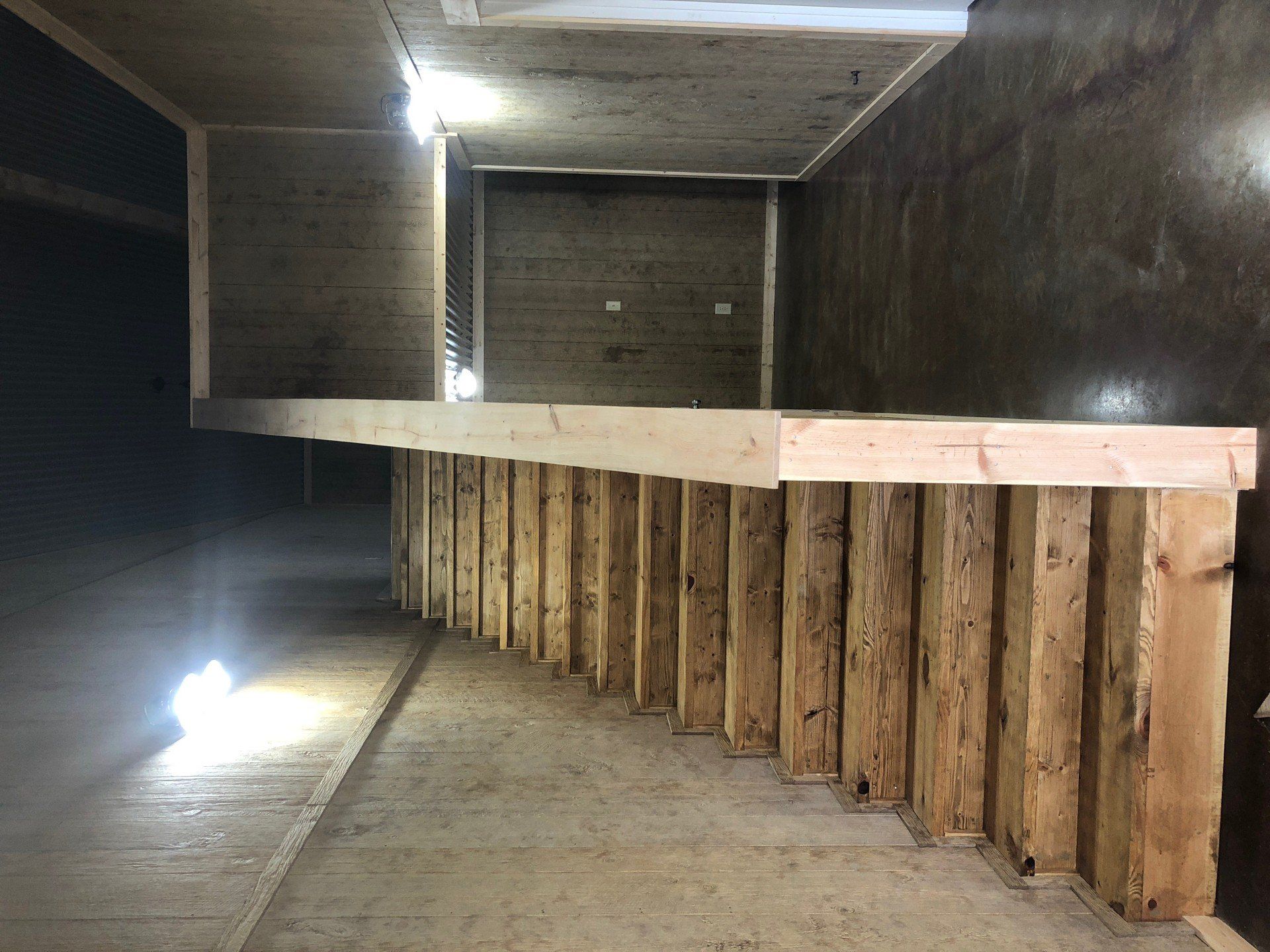 A wooden staircase is being built in a dark room.