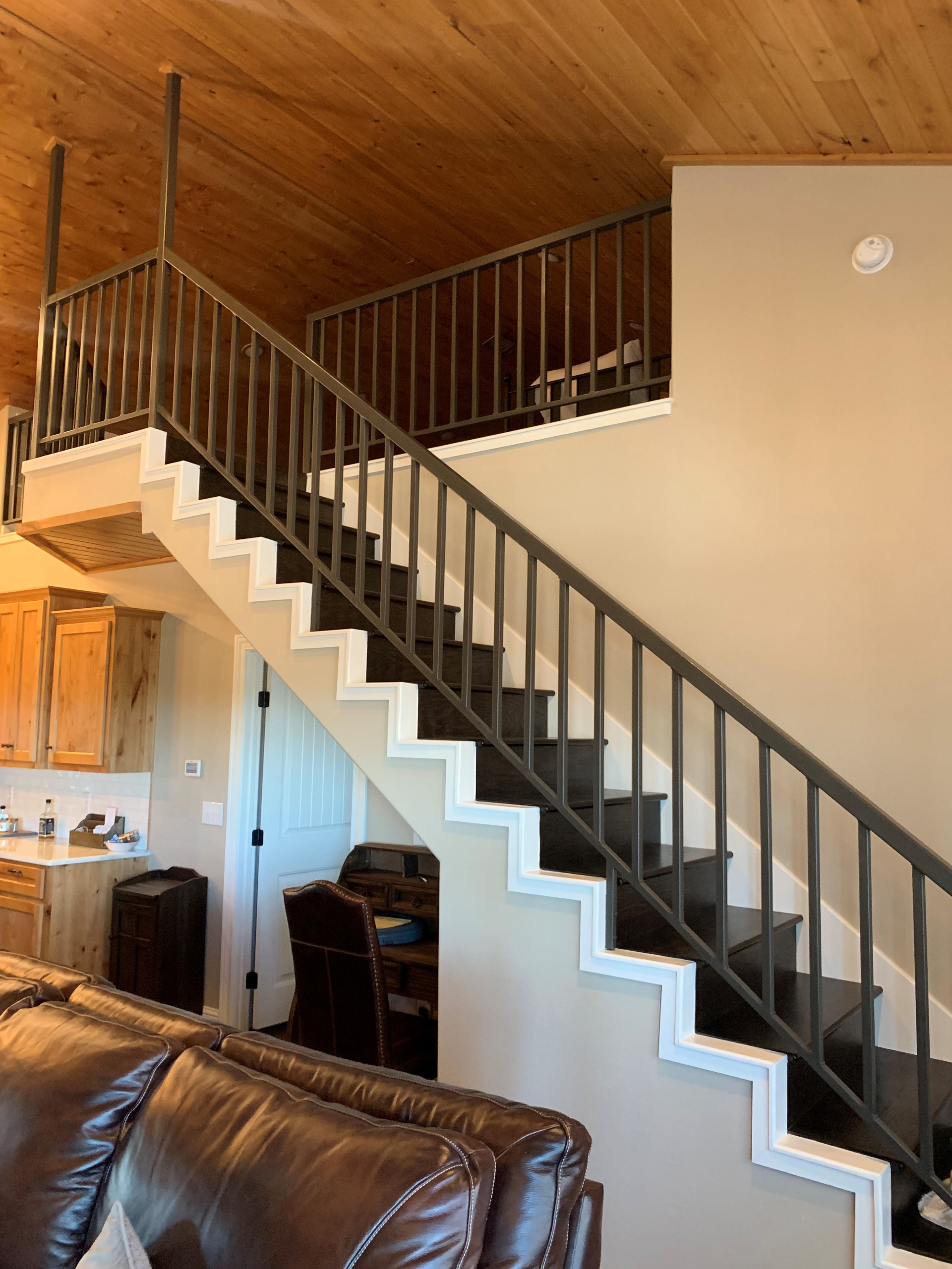 A living room with a staircase leading up to the second floor.