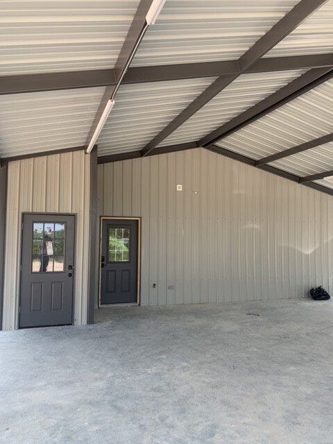 A large empty garage with a door and a window.