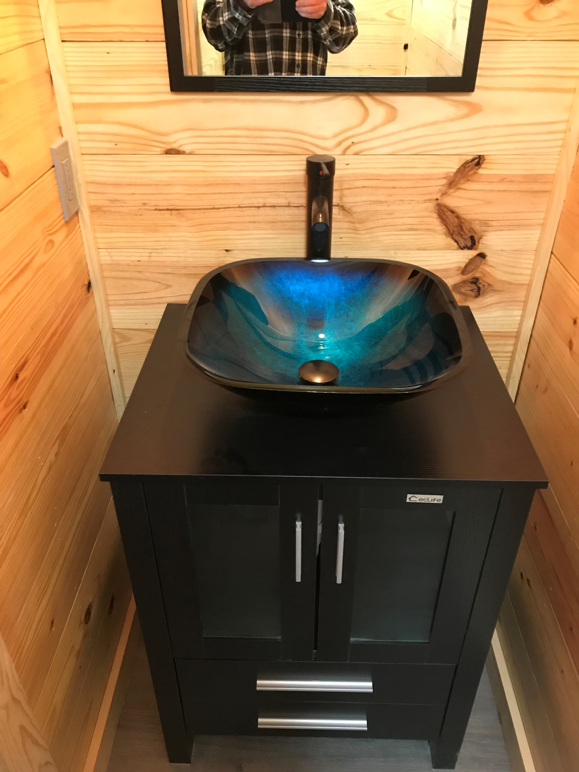 A bathroom sink with a blue bowl on top of it