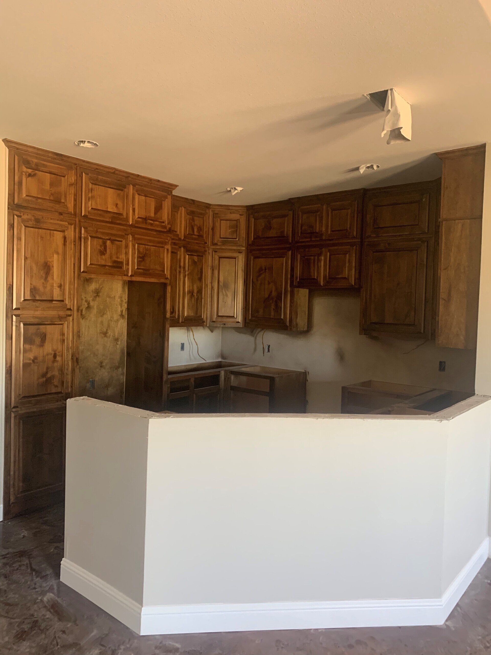 A kitchen with wooden cabinets and a white counter top.