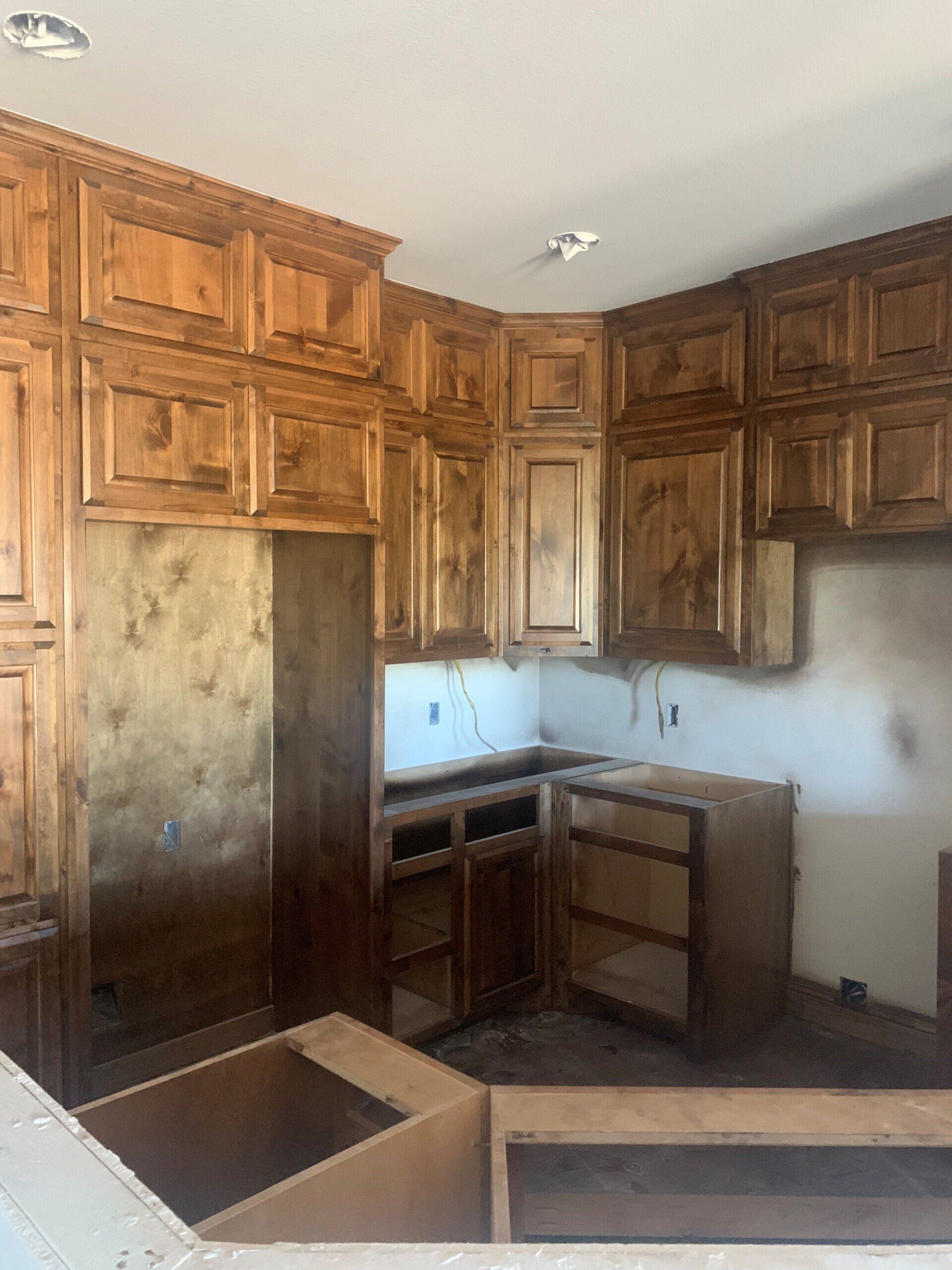 A kitchen with wooden cabinets and a stove top oven.
