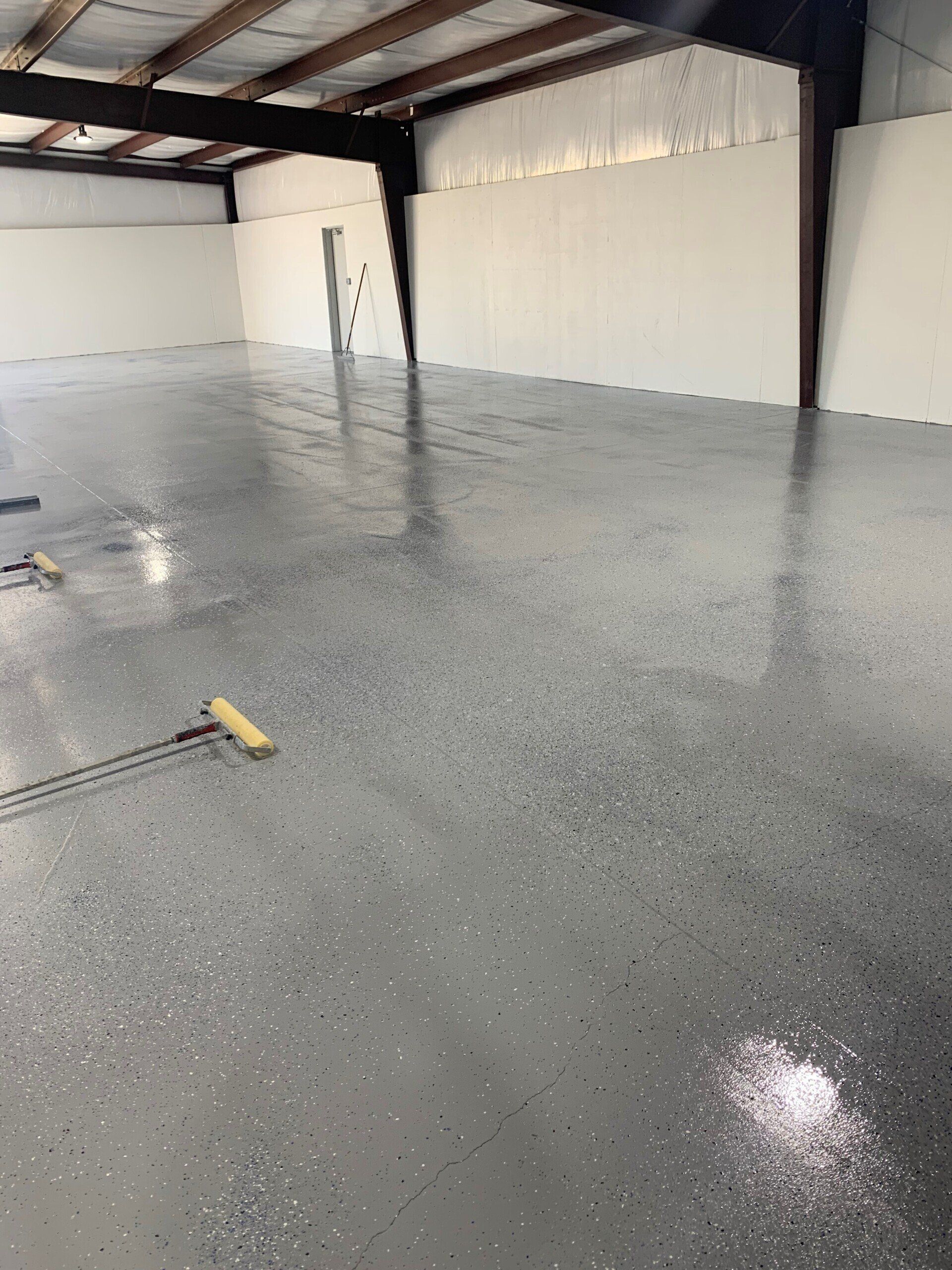 A large empty room with a gray floor and white walls