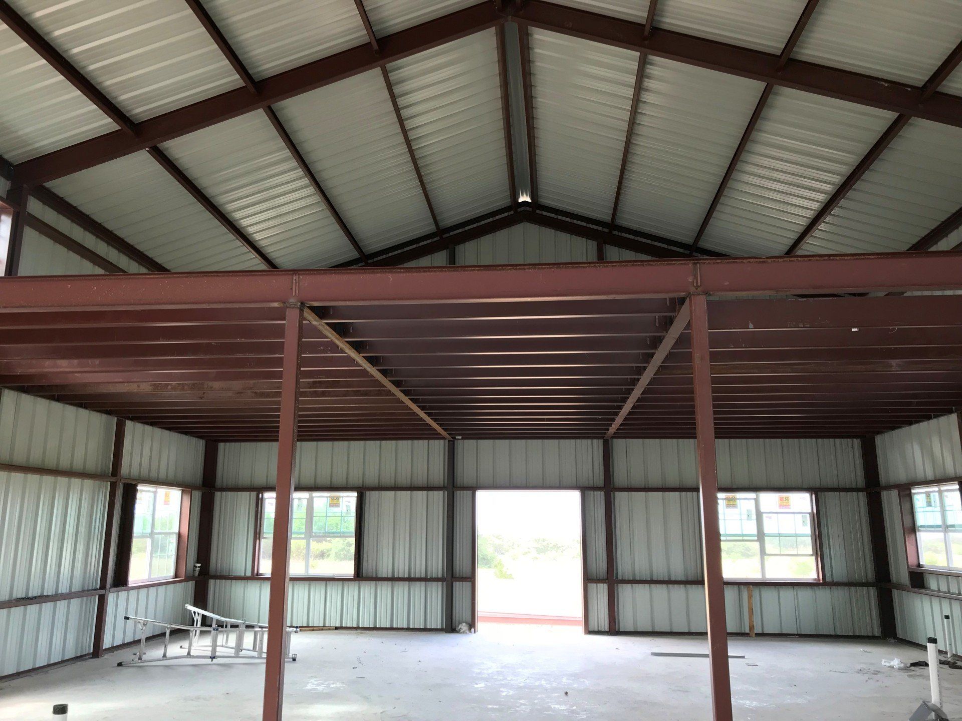 The inside of a building with a metal roof and a balcony.