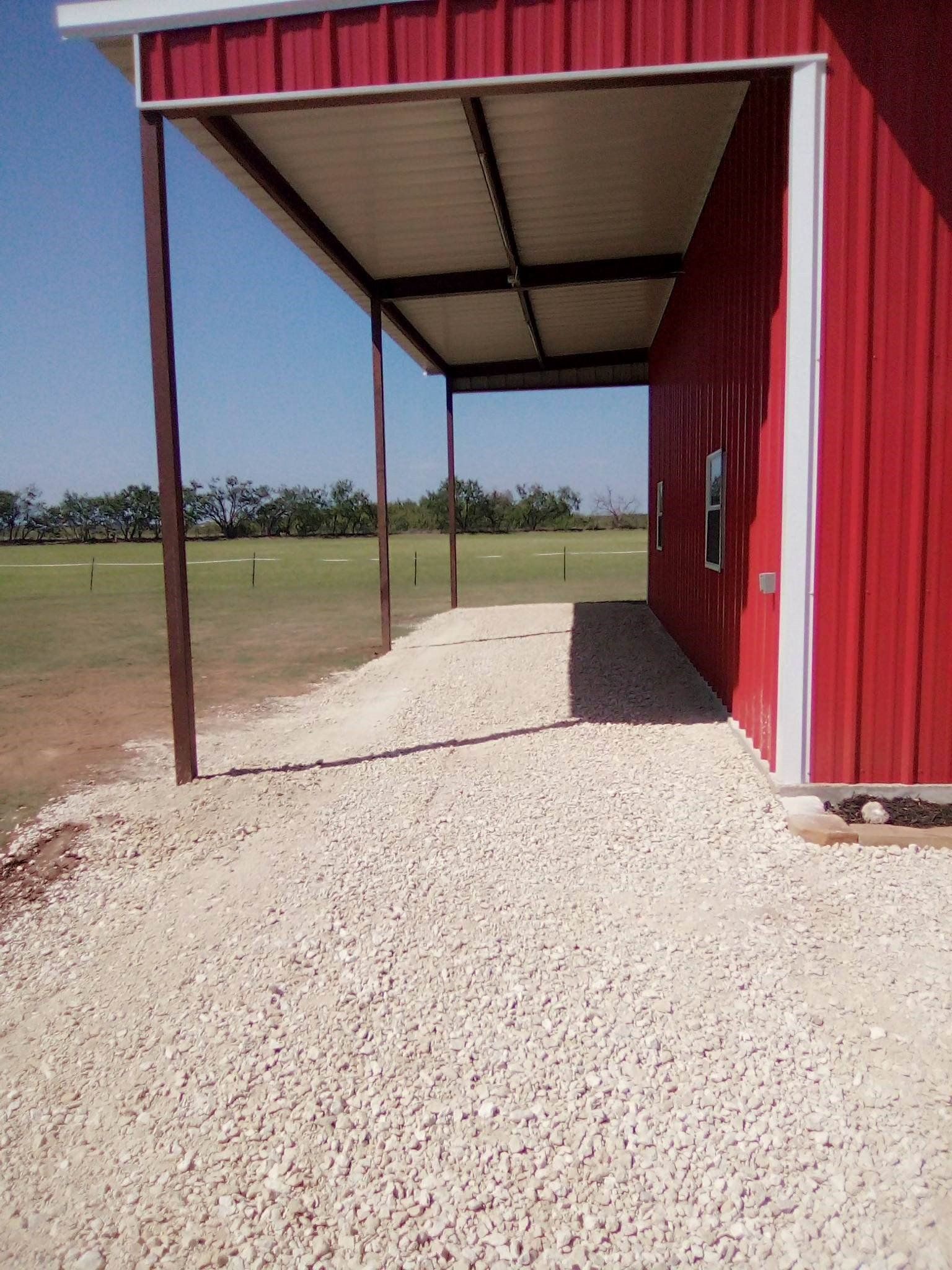 A red barn with a covered walkway leading to it