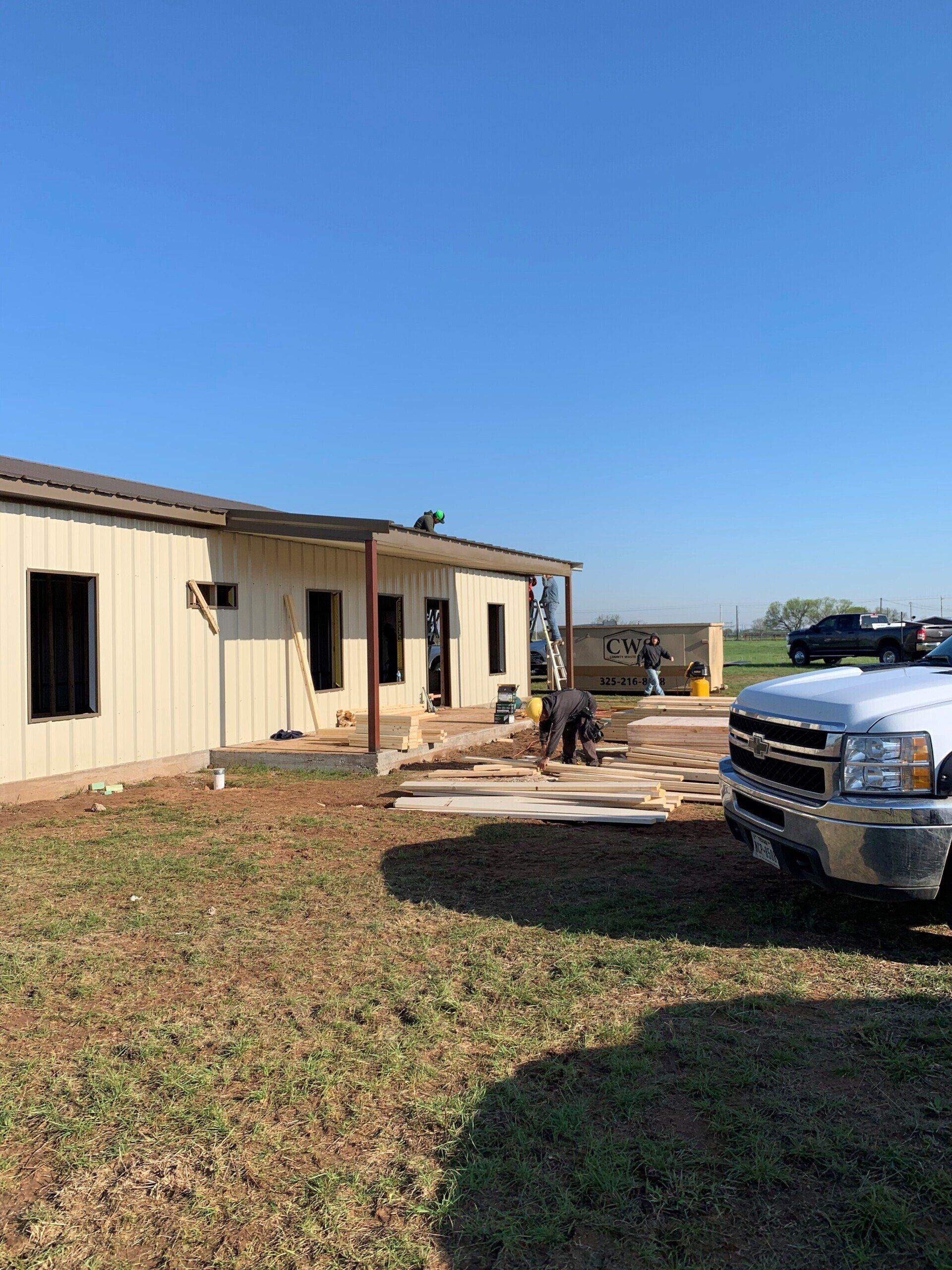 A truck is parked in front of a house under construction.