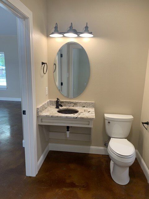 A bathroom with a toilet a sink and a mirror