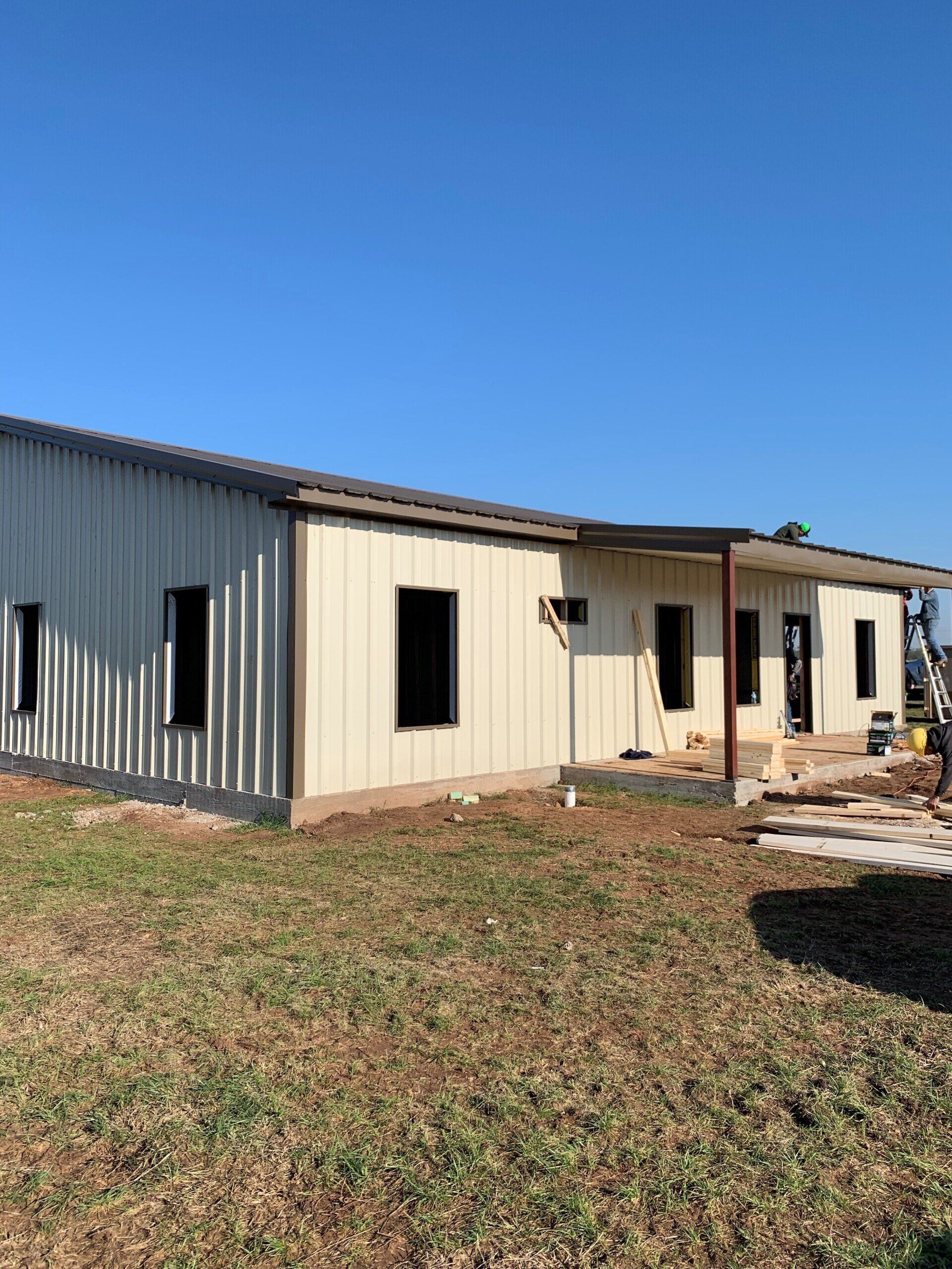 A house is being built in the middle of a grassy field.