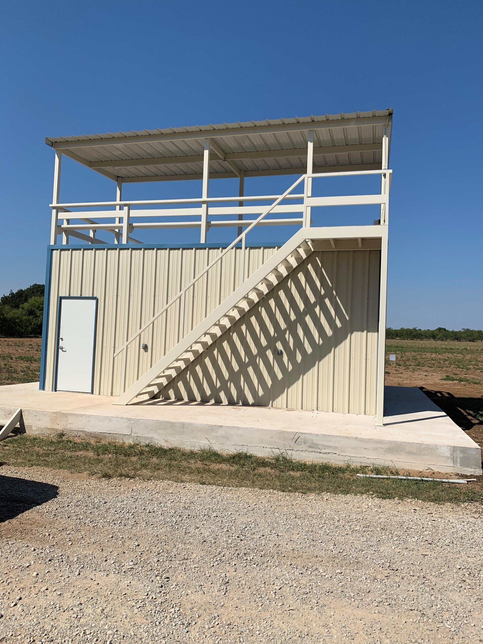 A small white building with stairs leading up to it