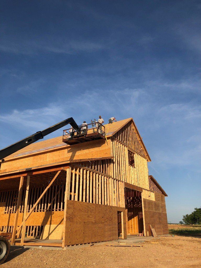 A large wooden building is being built with a crane on top of it.