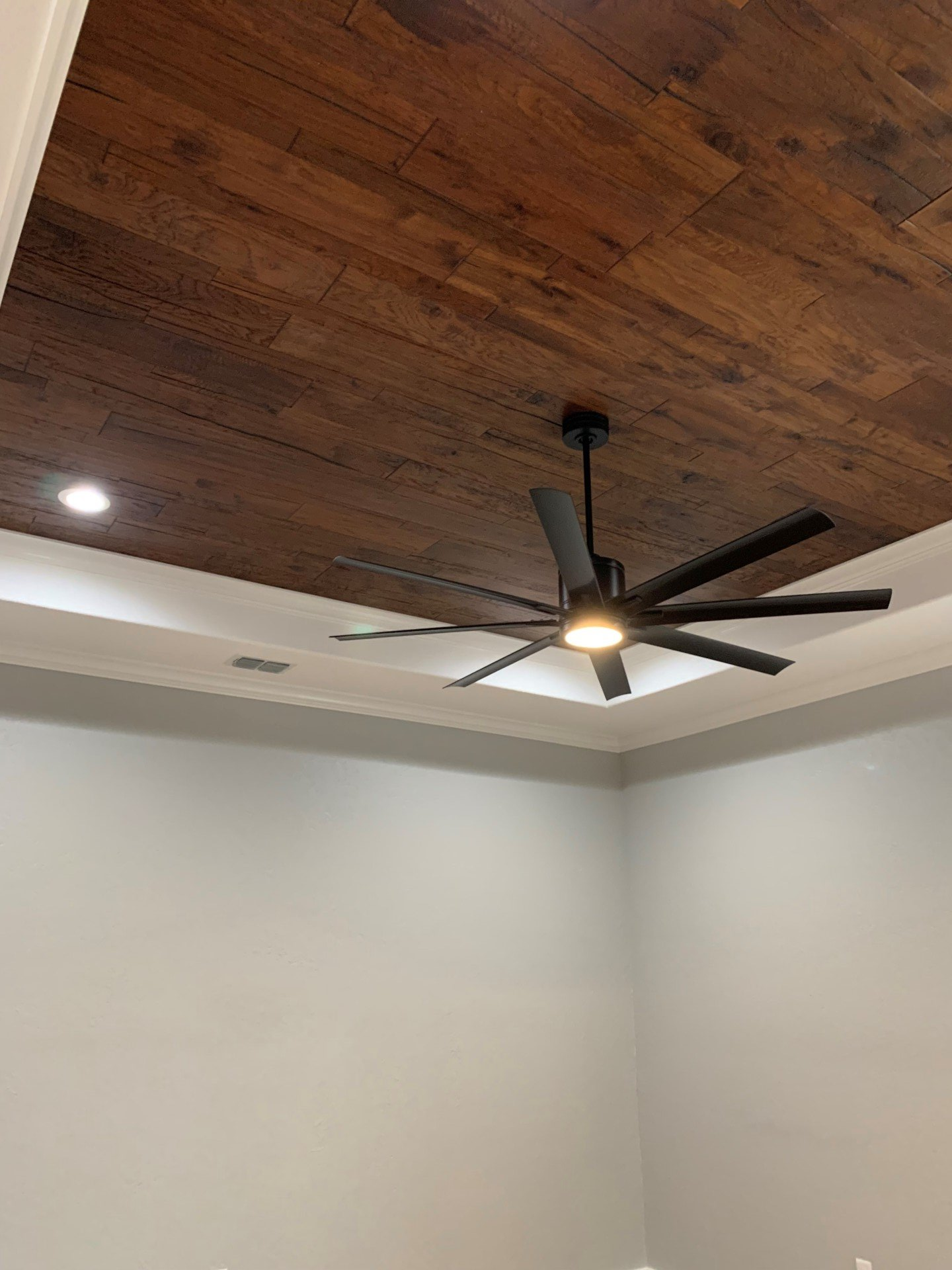 A ceiling fan is hanging from the ceiling of a room.