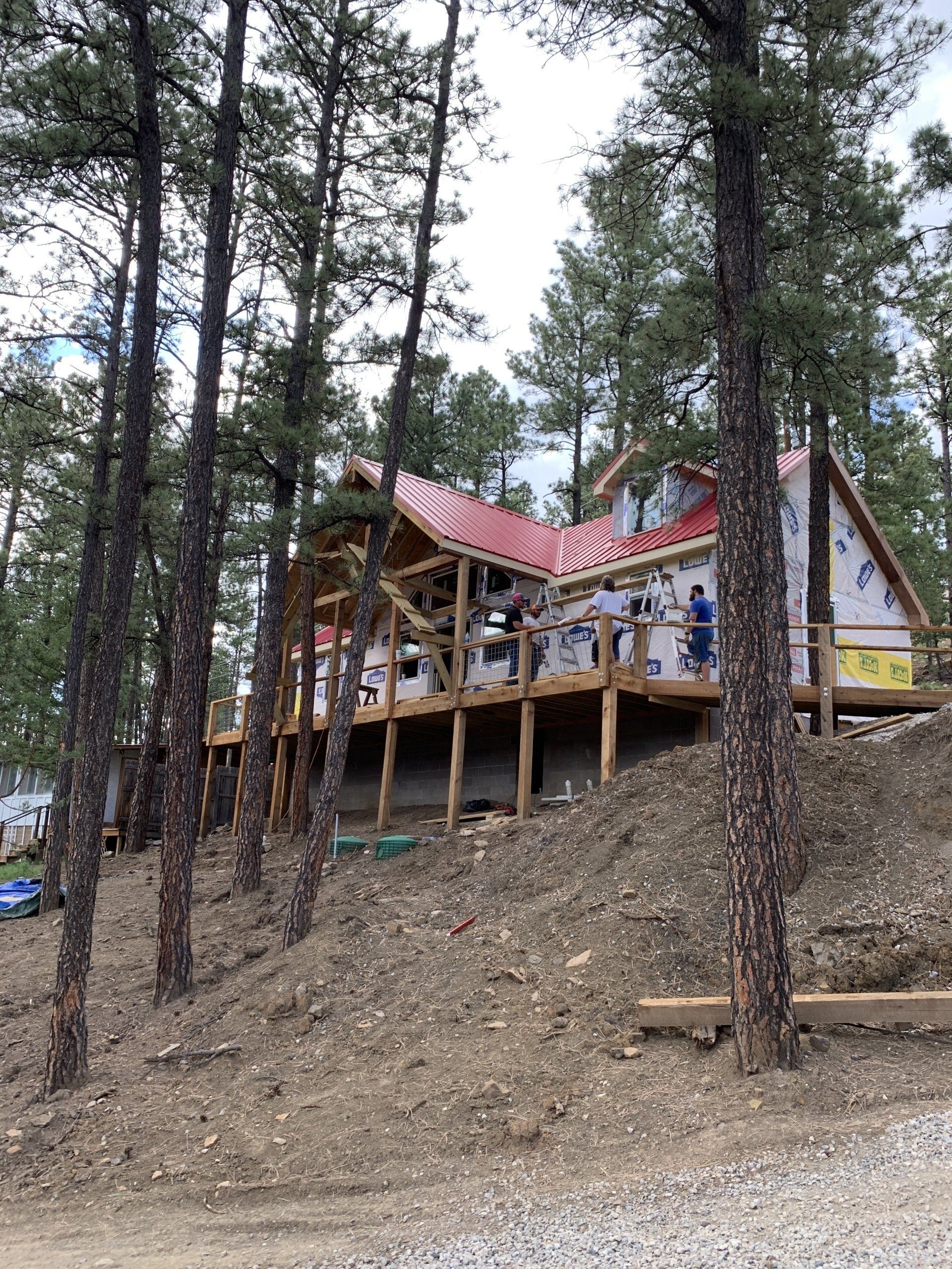 A house is being built on a hill in the middle of a forest.