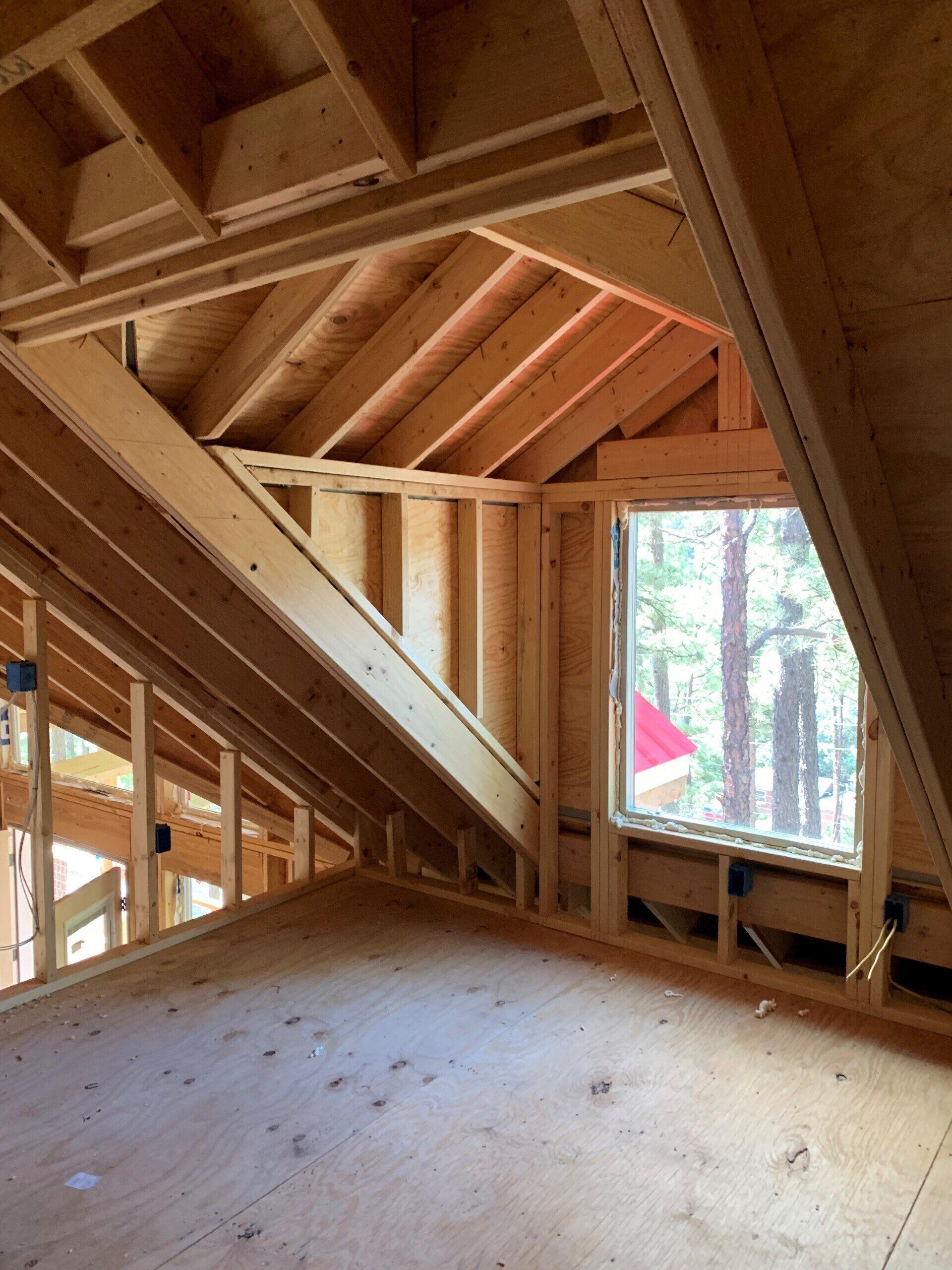 An attic in a house under construction with a window