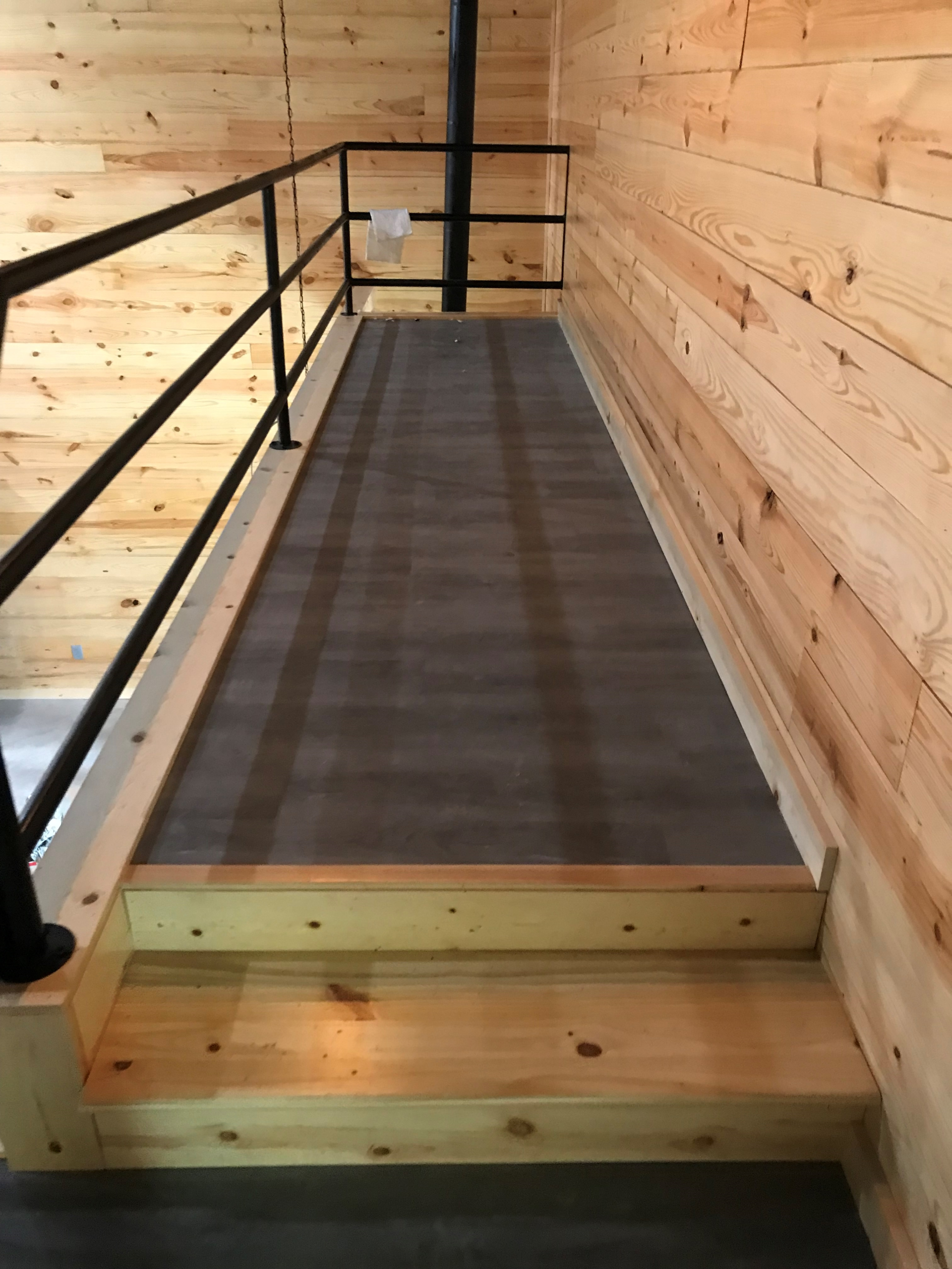 A wooden staircase with a metal railing in a wooden house