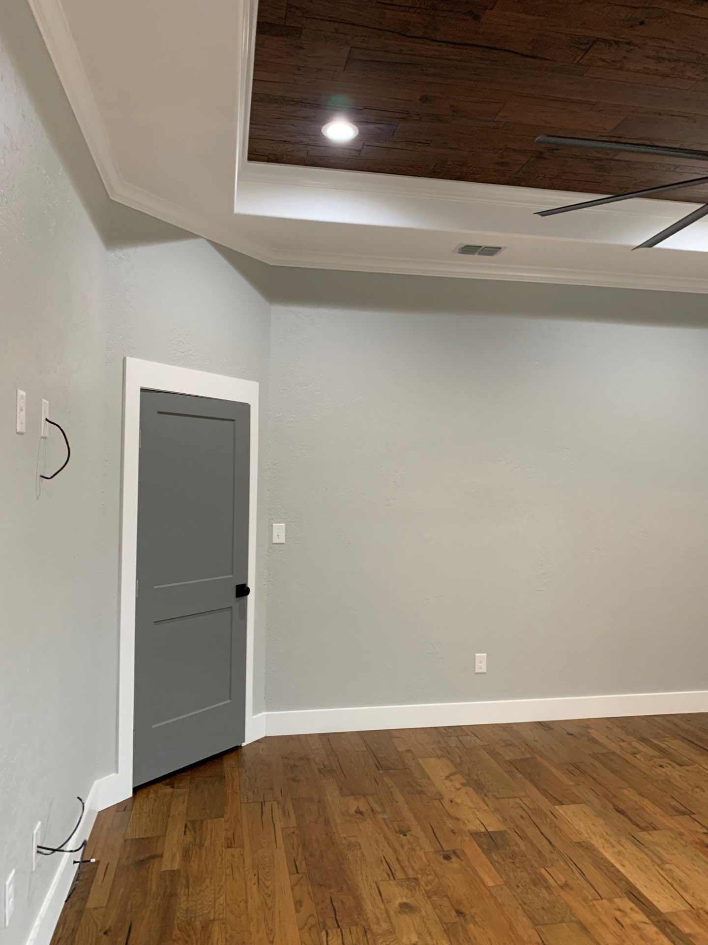 An empty room with hardwood floors and a ceiling fan.