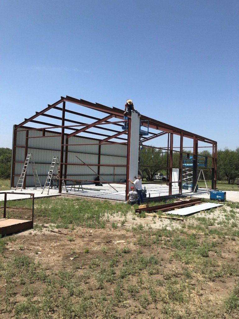 A large metal structure is being built in a field.