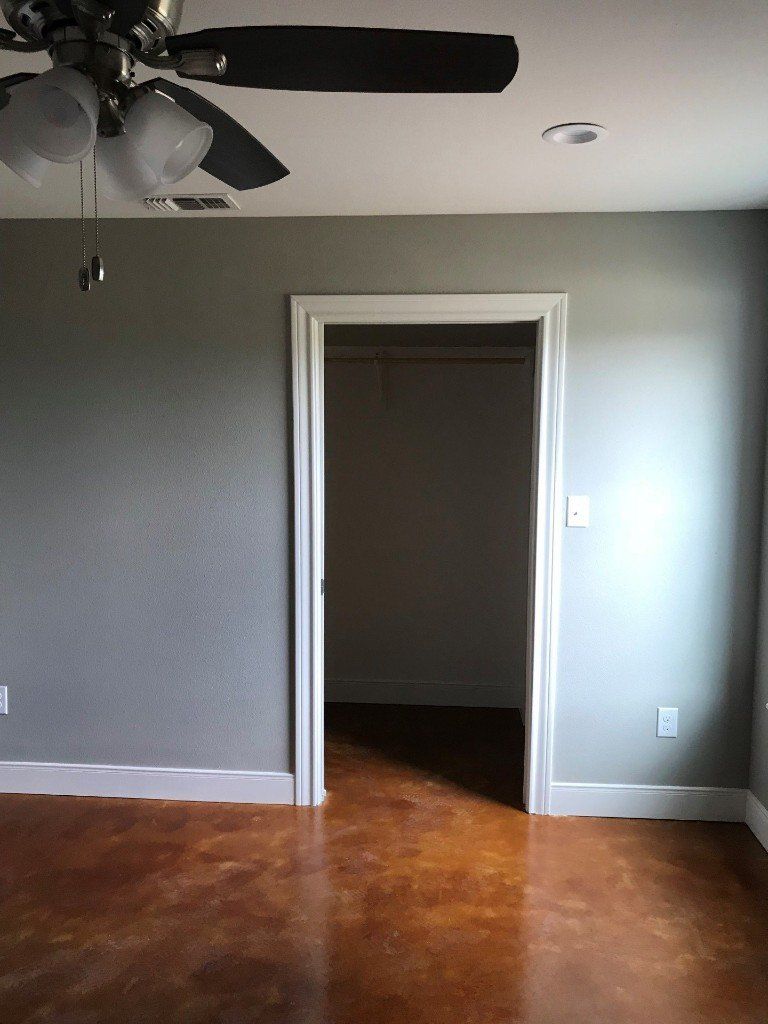 An empty room with a ceiling fan and a door leading to a closet.
